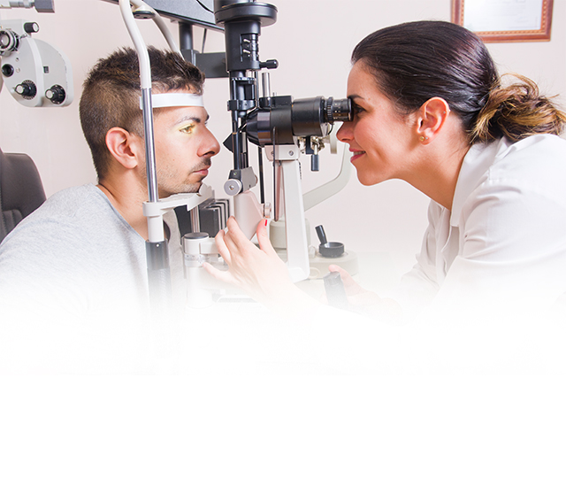 A smiling doctor gives an eye exam